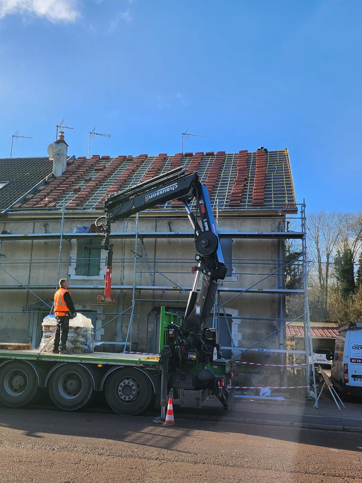 Chantier de toiture en Meuse : échafaudage monté et camion-grue pour approvisionner le toit